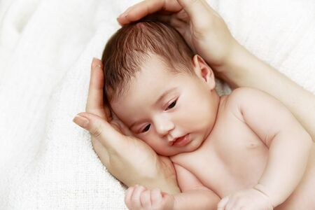 Cute newborn baby lying in mother's hands