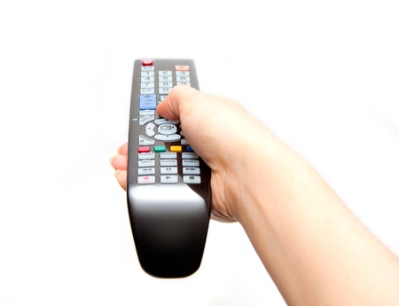 black TV remote in hand isolated on white background