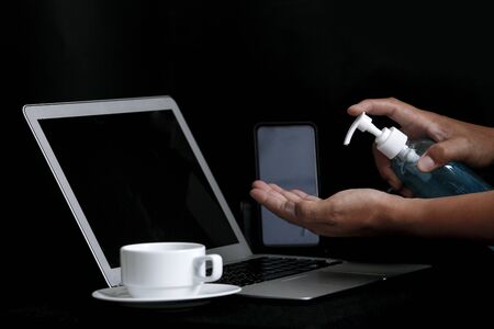 A man washing his hands with alcohol gel To prevent the corona virus While he works at home. On a...