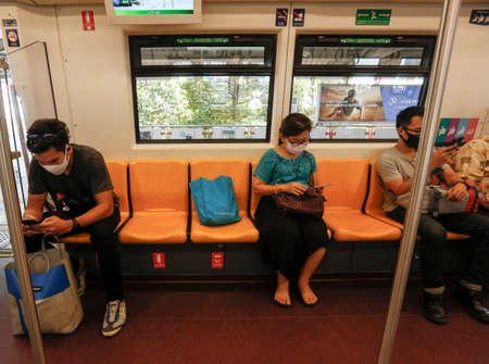 Bangkok, Thailand March 25, 2020. A passengers on a BTS train wear face masks to protect themselves from Covid-19.  Rail Department strictly requires all rail passengers to wear face masks and leave sufficient space between one another while travelling onのeditorial素材