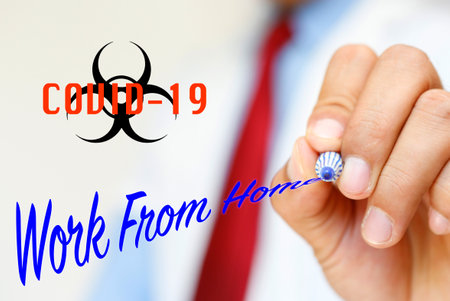 A man holding a pen to write the text "Work From Home"の写真素材