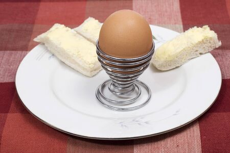 A boiled egg in egg cup with buttered soldiersの写真素材