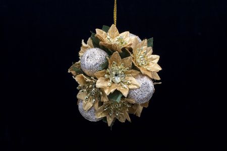 A gold and silver christmas decoration photographed against a black backgroundの写真素材