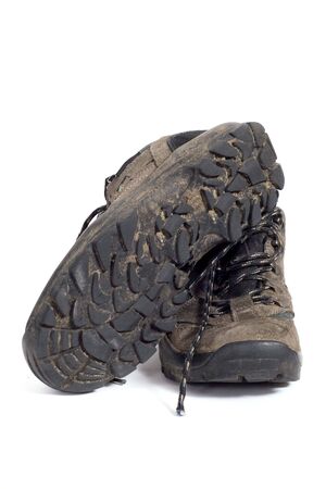 A pair of dirty hiking boots on a white backgroundの写真素材