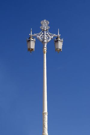 An old fashioned lamp post photographed against a bright blue skyの写真素材