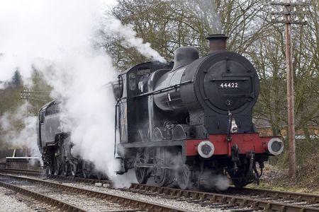 A steam engine pulls into a railway stationの写真素材