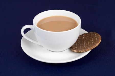 A cup of tea with a chocolate biscuit in the saucerの写真素材
