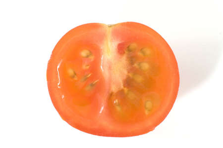 A juicy tomato sliced in half on a white backgroundの写真素材