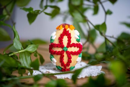 Easter egg made of paper, on a beautiful white napkin â€“ decoration of a holiday table during...