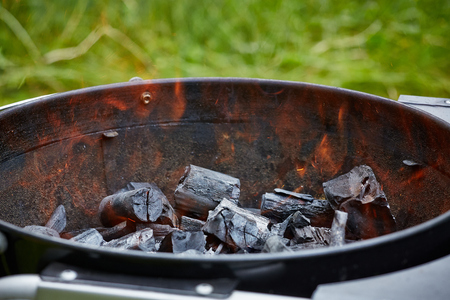 pieces of burning charcoal in grill outsideの写真素材