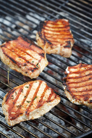four meat pieces preparing on grill. Vertical imageの写真素材