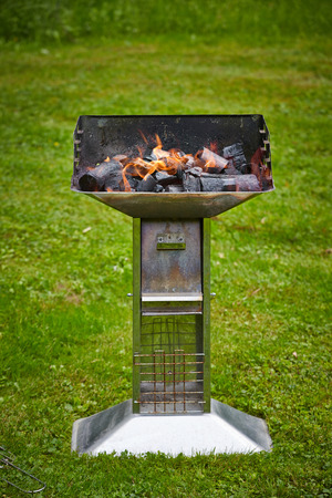 grill with burning charcoal pieces on grass full lengthの写真素材