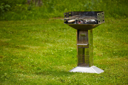 grill with burning charcoal on grass laneの写真素材