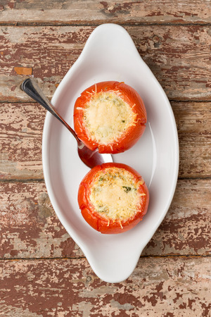 prepared stuffed tomatoes with cheese on white plate. Vertical image.の写真素材