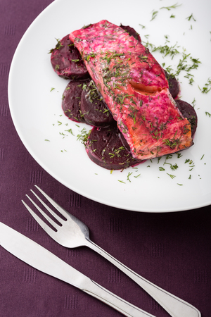 prepared salmon fillet with beet and sauce on white plate. Vertical image.の写真素材