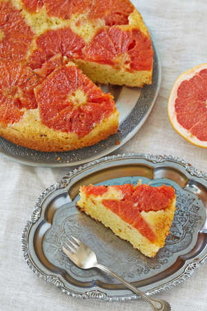 a sponge cake with grapefruit slices on a grey backgroundの写真素材