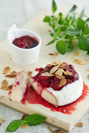 baked camambert cheese with jam decorated with almondの写真素材