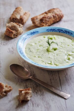 avocado cucumber soup with yoghurt on a wooden tableの写真素材
