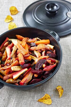 baked fruit and vegetables with almonds in the black cooking panの写真素材