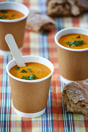 appetizing vegetable creme soup in paper cups in the checked backgroundの写真素材