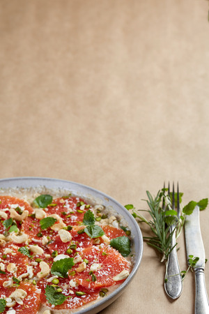 uncooked round grapefruit pie with ceshew and mint leavesの写真素材