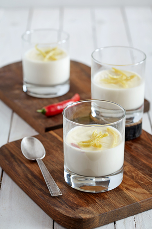 an image of three glasses of tasty vanilla panna cotta decorated with pineapple citron chips on the cutting boardsの写真素材