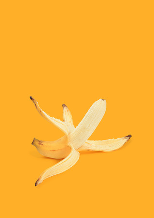 Peeled banana on yellow backgroundの写真素材