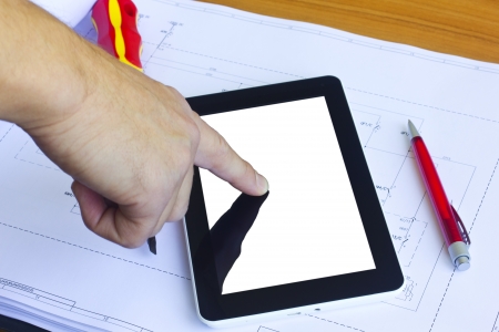 Man working with tablet computer over engineering diagramの写真素材