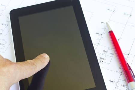 Man working with tablet computer over engineering diagramの写真素材