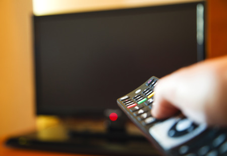 Man holding remote control for smart TV
