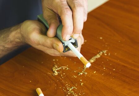 Man rolling cigarettes using fresh tobaccoの写真素材
