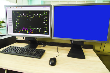 Computers and monitors with schematic diagram for supervisory, control and data acquisition in modern electrical control roomの写真素材
