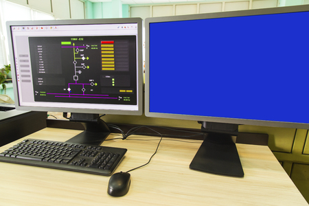 Computers and monitors with schematic diagram for supervisory, control and data acquisition in modern electrical control roomの写真素材