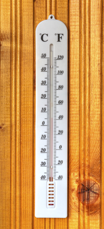 Classic thermometer on wooden board closeup