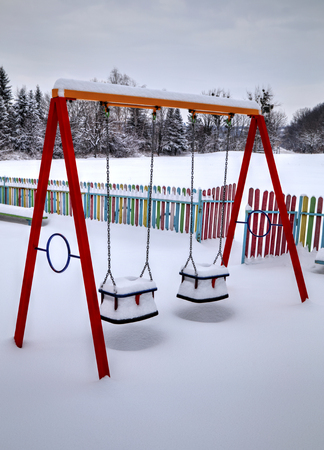 Children's playground covered with snow in winterの写真素材