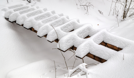 Wooden bridge covered with snow in winterの写真素材