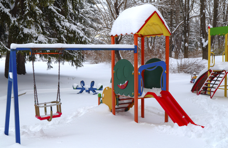 Children's playground covered with snow in winterの写真素材