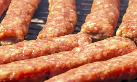 Grilling fresh meat on barbecue close up view
