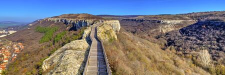 Beautiful view with wooden bridge leading thru an autumn landscape to the horizonの写真素材