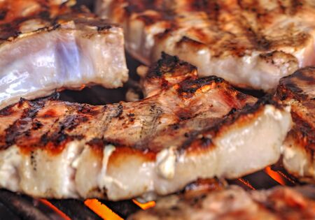 Grilling fresh meat on barbeque close up view