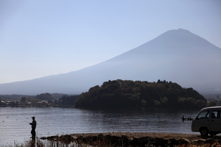 A man fishing at kawaguchiko lake with mt  fuji in backgroundの写真素材