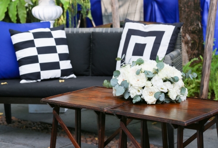 Wood table decorated with white roses and sofasの写真素材