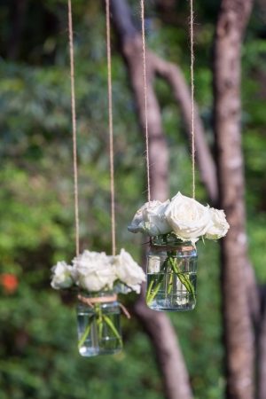 White roses in a glass vase hung in a wedding partyの写真素材