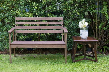 Wood bench decorated with white roses in a grass vaseの写真素材