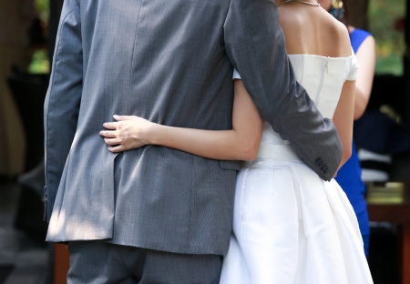 Newlywed put their arms around each others waistの写真素材