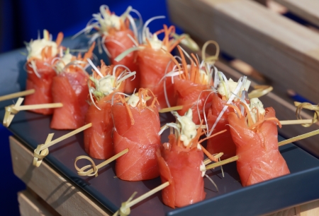Colorful salmon canapes on a blue trayの写真素材