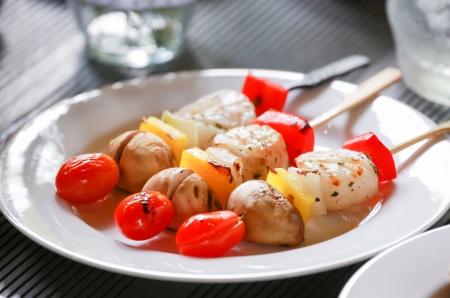 Three colorful barbeque sticks on a white plateの写真素材