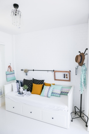 Colorful pillows on a sofa with white brick wall in background