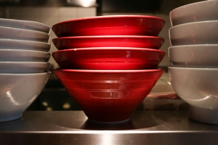 Red and white ceramic noodle bowl on the shelfの写真素材