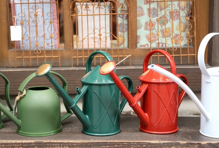 Colorful watering cans outside the windowの写真素材